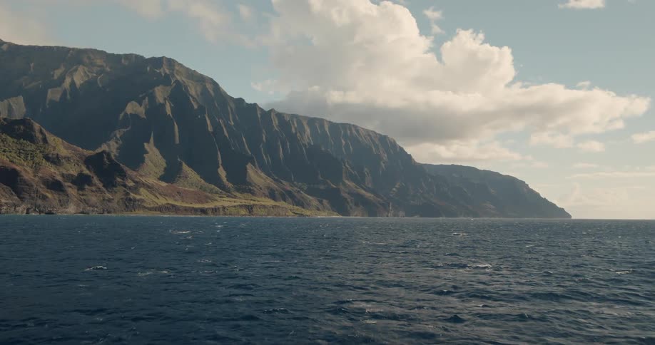 The waves flow by the tall mountain