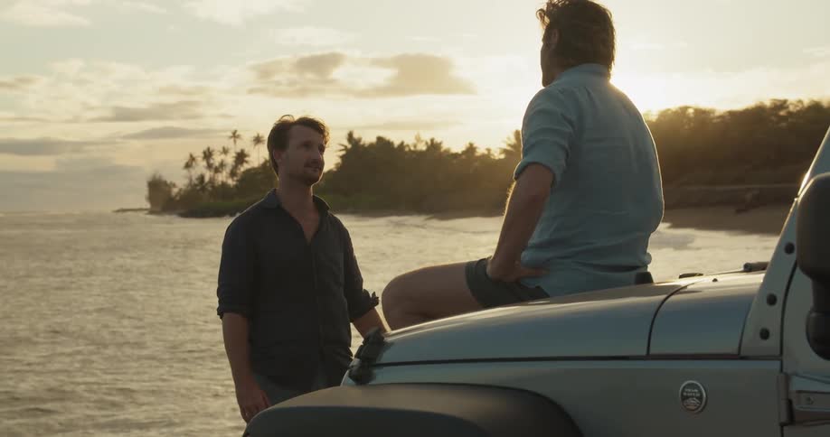 Two men talk by the water