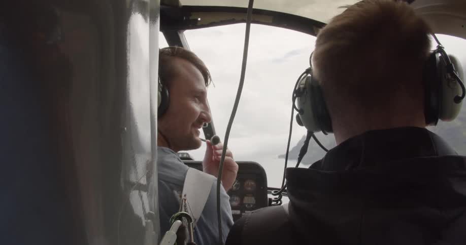 Two men fly in a helicopter