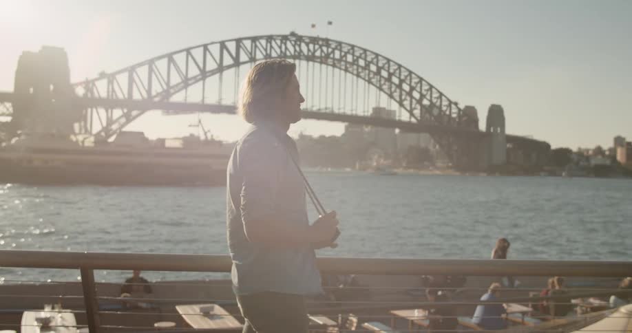 A man holds a camera and photographs a boat