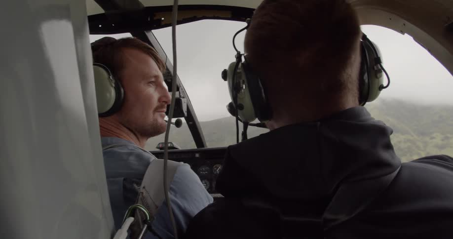 Two men ride in a helicopter