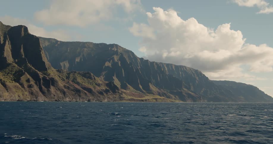 Clouds are drifting over coastal cliffs during daylight