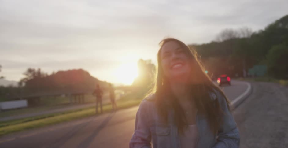 A woman takes a  photograph at sunset