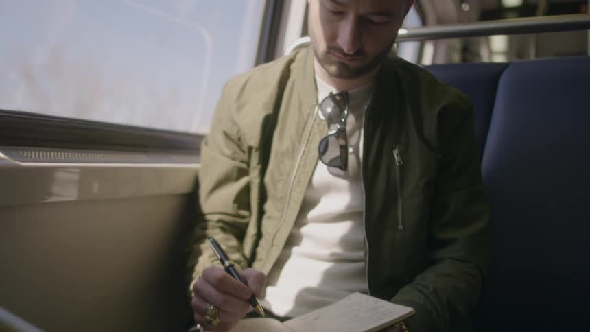 Man journals while riding public transit