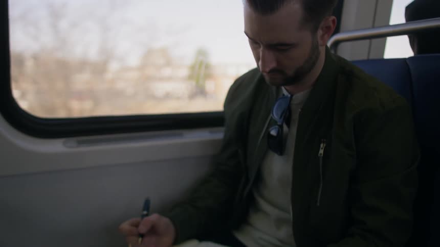 Man journals while riding public transportation