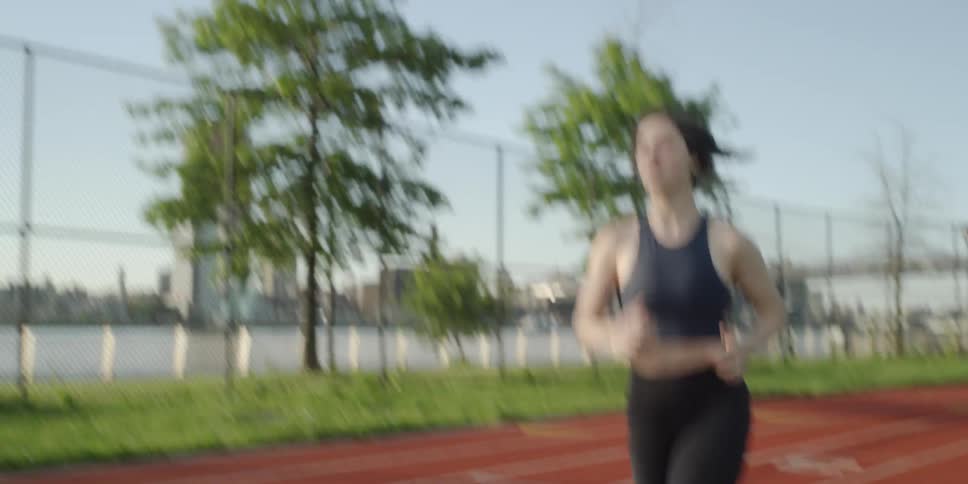 Woman jogs on a track near trees