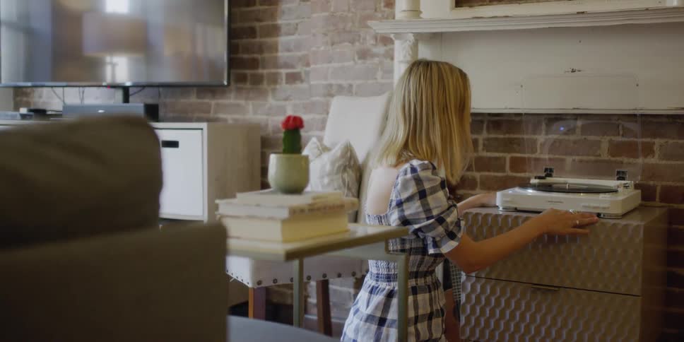 A woman puts a record on the player
