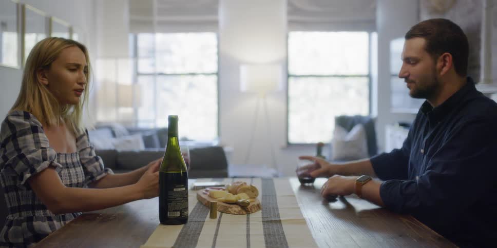 Two people sit down at the table talking and drinking