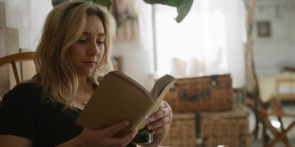 A woman is reading a book in the living room
