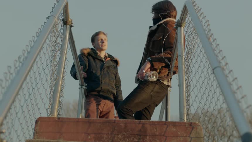Two people talk together up the steps