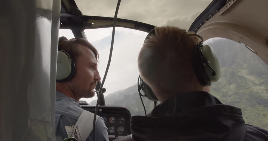 Two men ride in a helicopter
