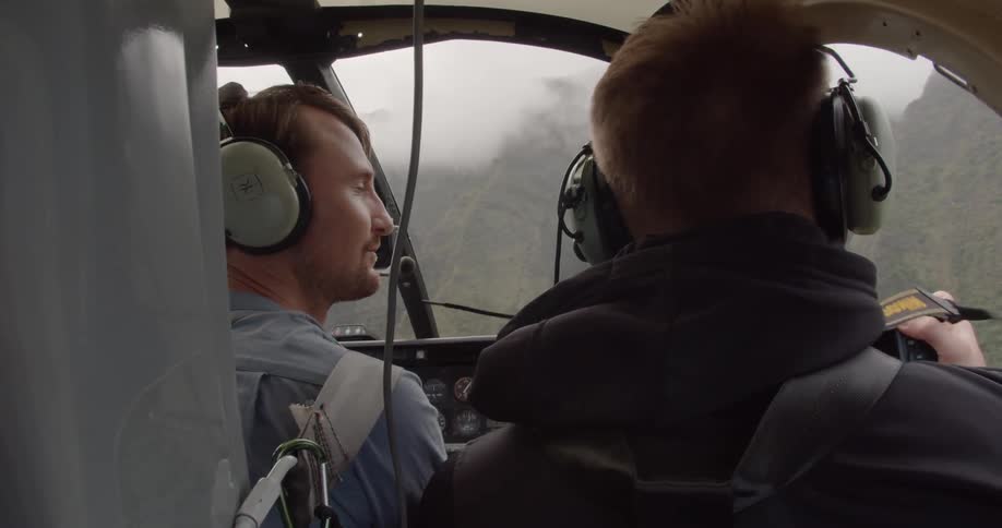 People are looking around as they ride in a helicopter