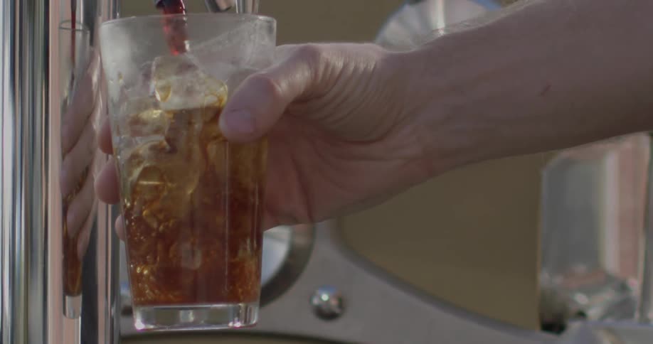 A drink is poured into a glass of ice