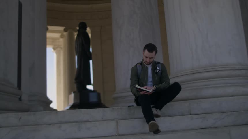 Man reads on the steps of the thomas jefferson memorial