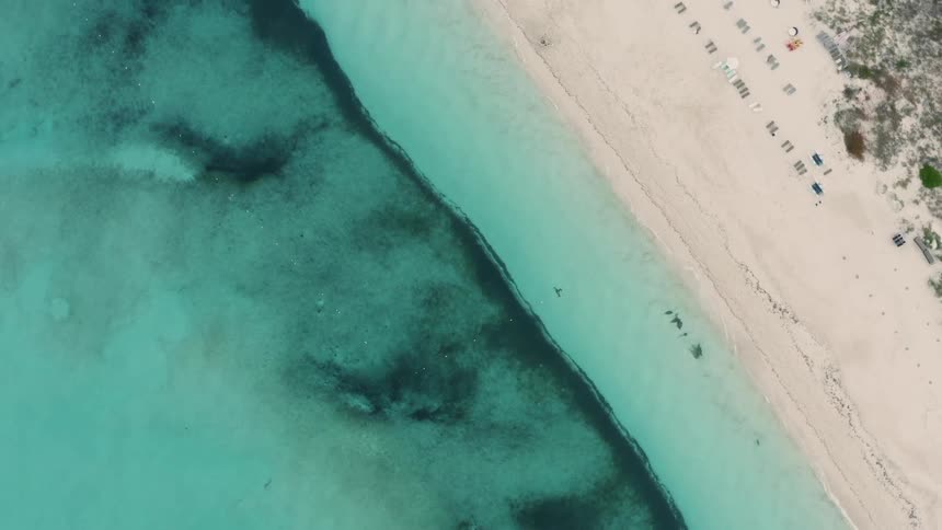 People are sitting on the beach below