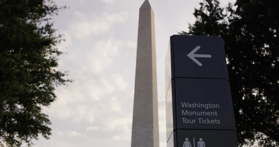 A sign sits in front of the washington monument