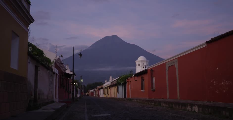 A view down the length of a deserted town street with a mountain peak in the distance