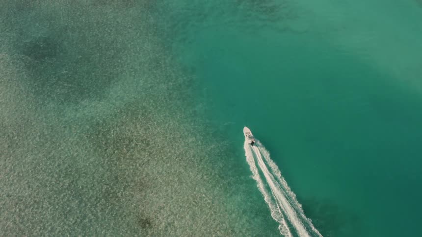 Boat travels through the water creating waves behind it