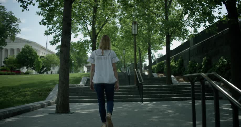Woman walks in a park on a summer day