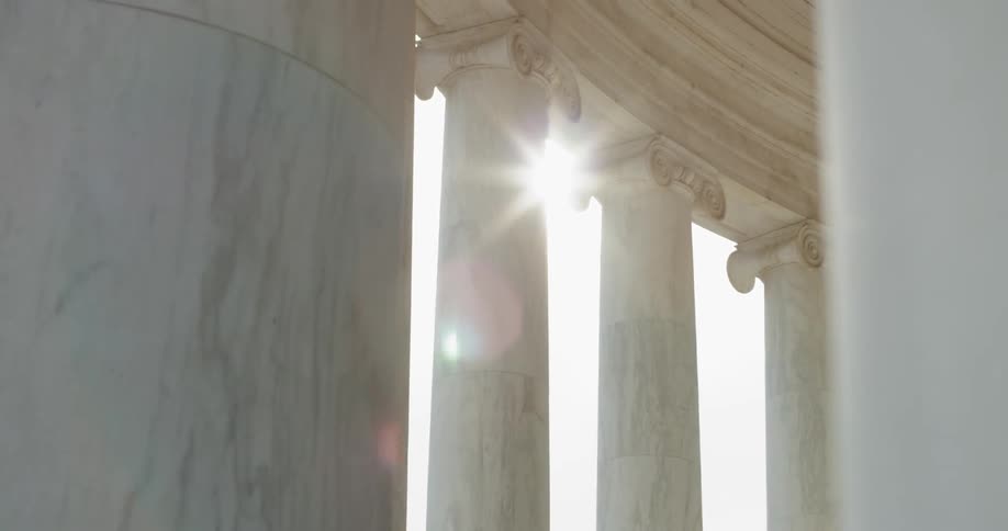 Sun shining through Stone pillars of Jefferson Memorial in Washington DC