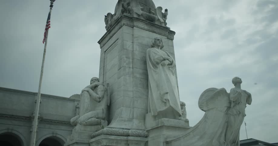 A monument is surrounded by statues of people