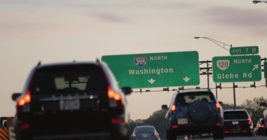 Cars drive under Washington DC highway sign