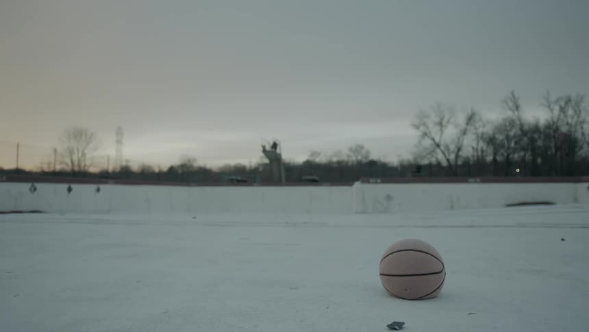 A basketball sits in the empty pool