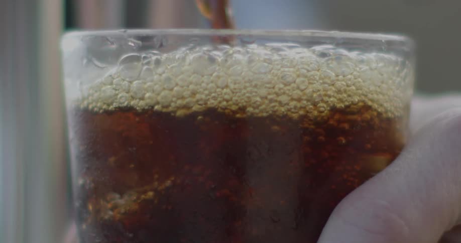 A drink is poured into a glass