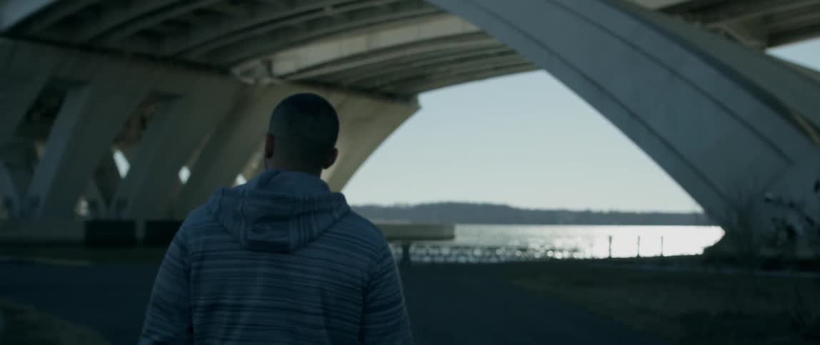 A man is walking towards the water