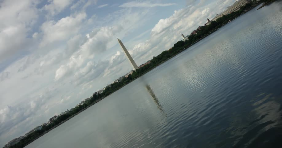 The washington monument towers beyond the river