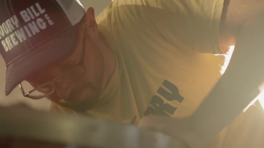 A man scoops ingredients in a brewery