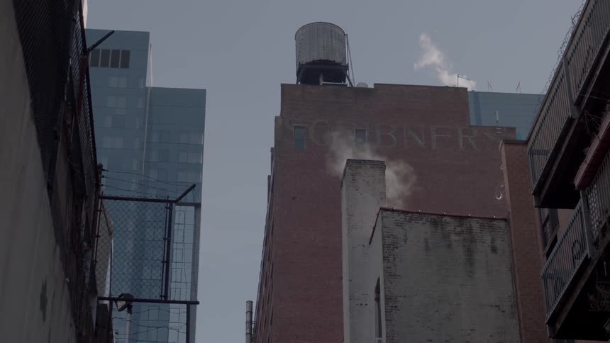 A water tower stands on a building rooftop