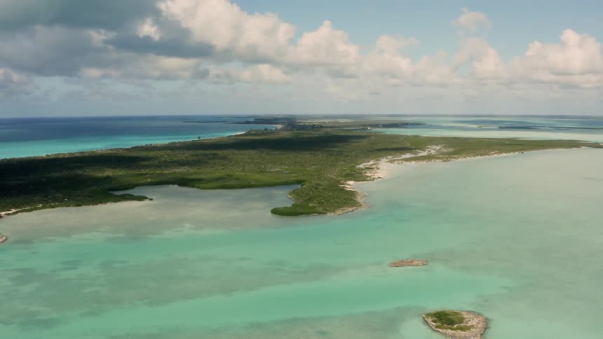 Clear blue water flows around the narrow island