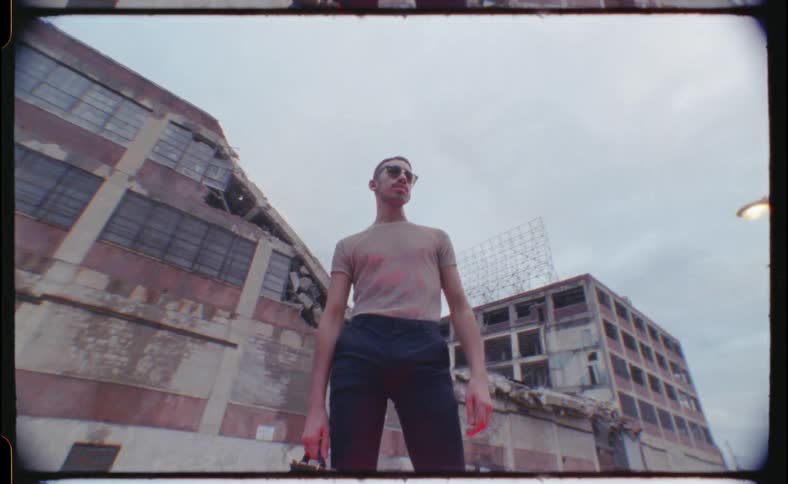 A man stands in front of a building holding a briefcase
