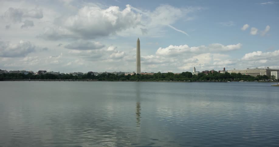 The washington monument towers beyond the river