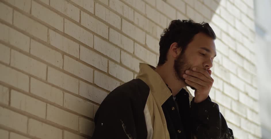 A person standing up against a wall