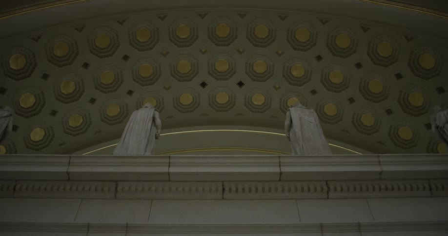 The stone building has statues of people above