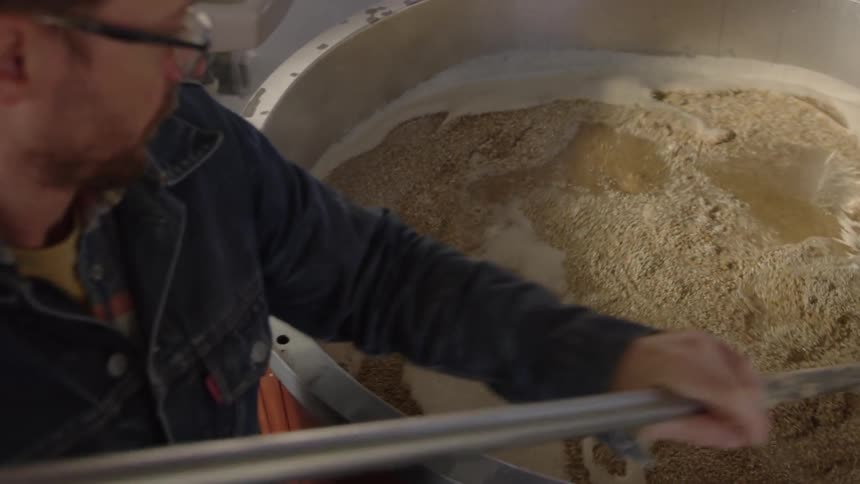 A man is mixing yeast in a vat