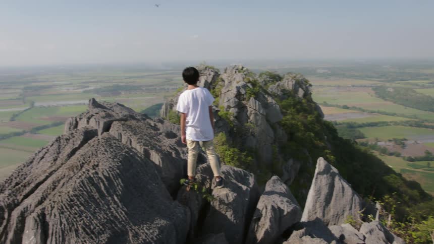 A person is standing on the top of the mountain