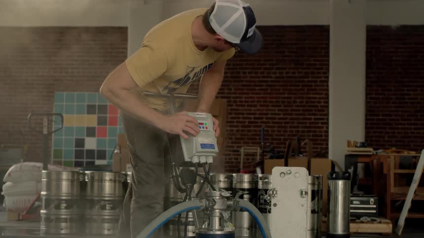 A man is working on a machine in a brewery