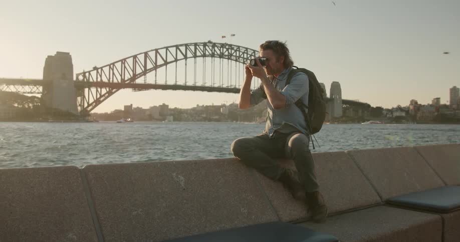A man takes photos by the water