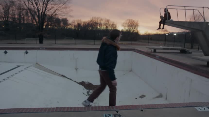 A man walks past the empty pool at dawn