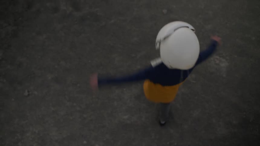 A child in a white helmet spins around