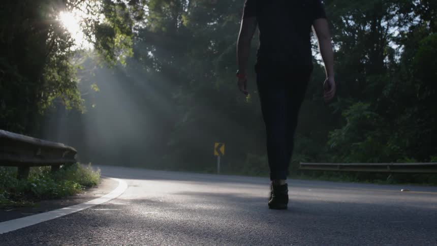 A man walks down a forest road