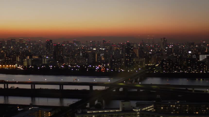 Cars drive on a city bridge at sunset