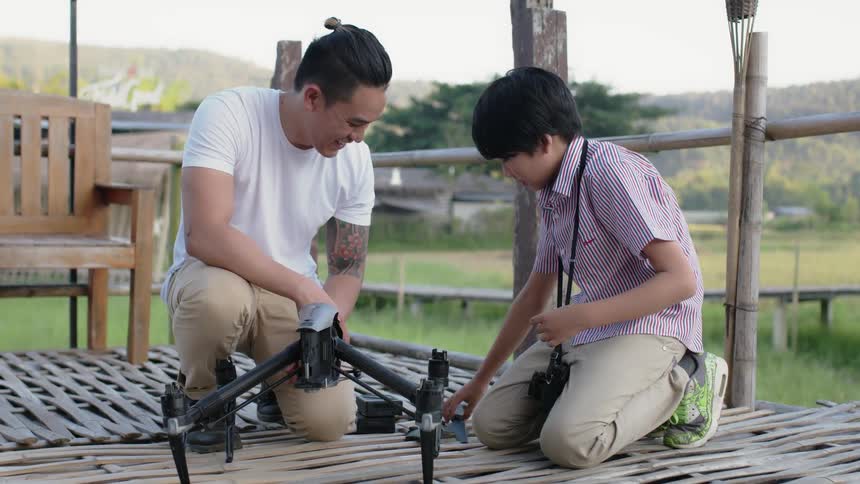A man and boy work on a drone