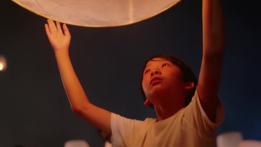 People hold paper lanterns into the air