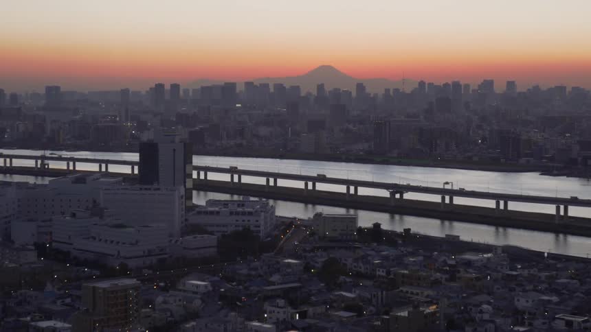 Cars drive on a city bridge at sunset