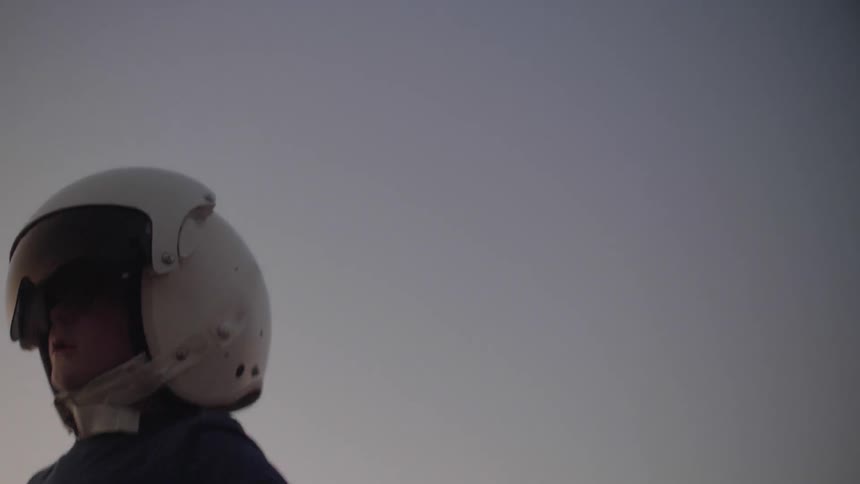 A young boy runs while wearing a helmet