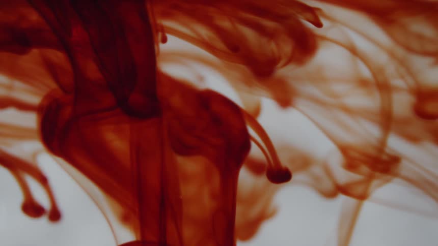 The red liquid mixes in the water
